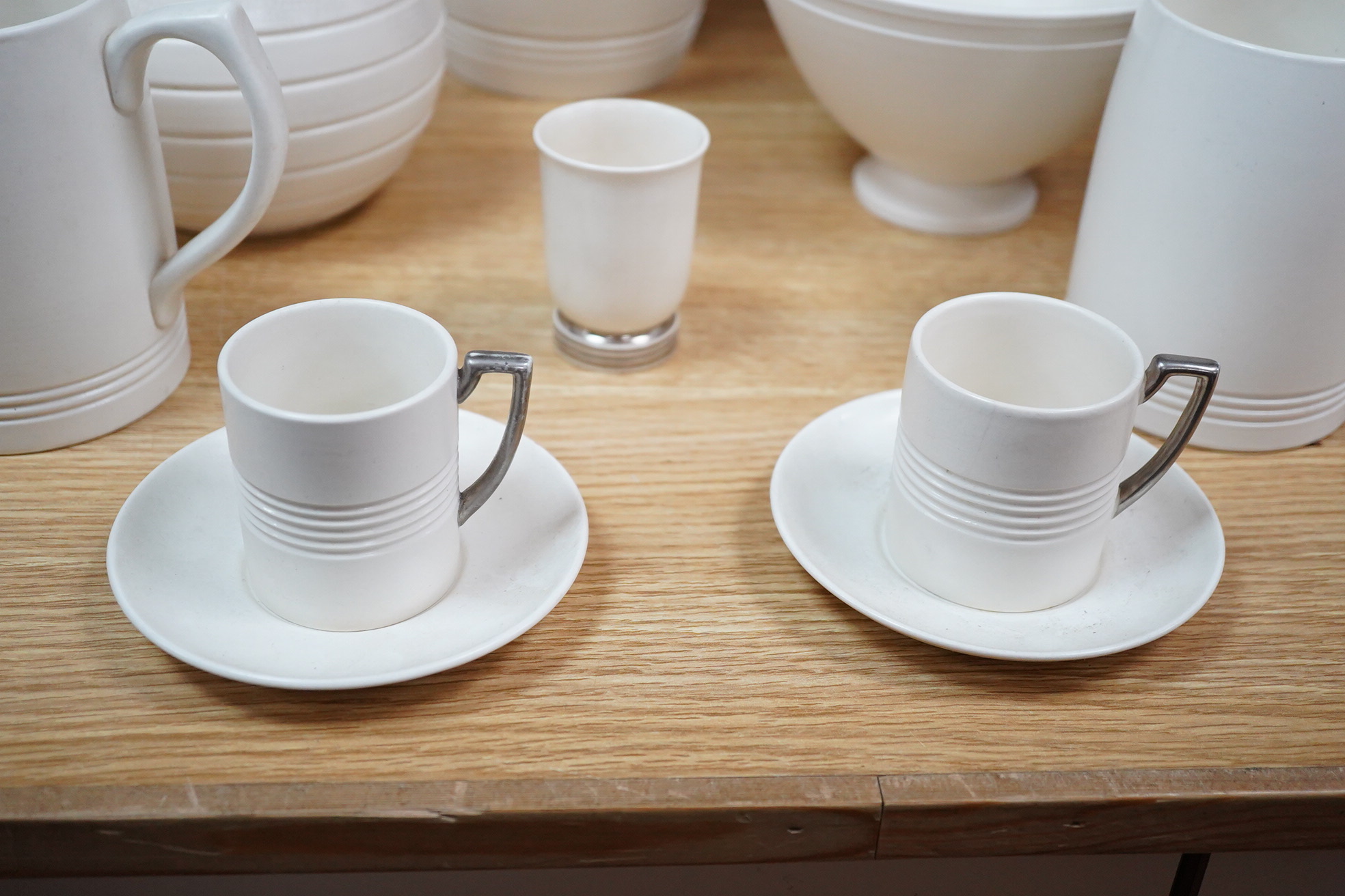 Keith Murray for Wedgwood, moonstone bowl, vase, jug, two mugs, coffee cups and small vase, largest 21cm high